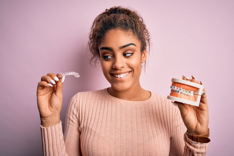 A girl holding a set of clear aligners